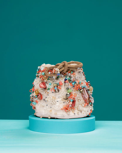 White beaded Colombian Wayuu handbag featuring floral embroidery and druzy quartz"

